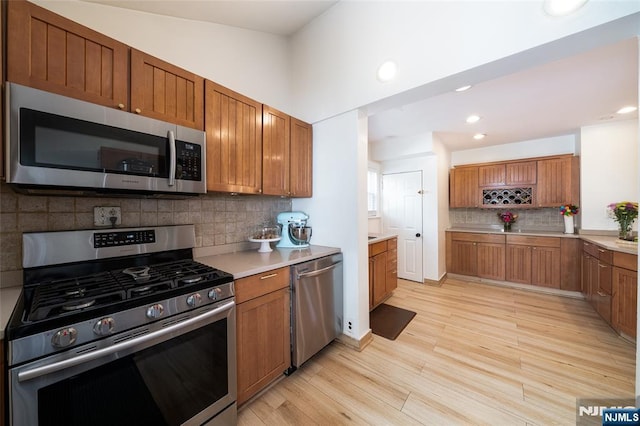 1096 Stasia St, Teaneck, NJ 07666 - kitchen featuring stainless steel appliances, brown cabinetry, backsplash, and recessed lighting