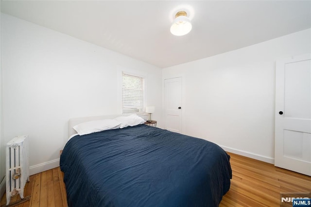 1096 Stasia St, Teaneck, NJ 07666 - bedroom featuring radiator, light wood-style floors, and baseboards