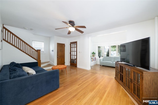 1096 Stasia St, Teaneck, NJ 07666 - living room with stairway, light wood-style flooring, a ceiling fan, and healthy amount of natural light