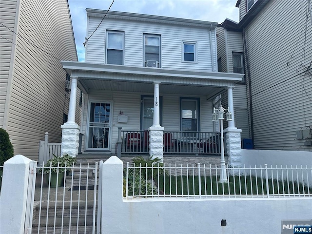 140 Oak St, Paterson, NJ 07501 - townhome / multi-family property featuring covered porch and a fenced front yard