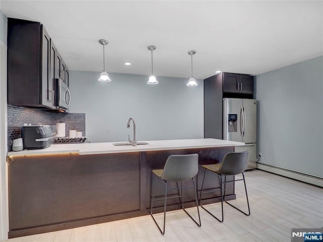 2200 Paterson Plank Rd Unit 19, North Bergen, NJ 07047 - kitchen featuring appliances with stainless steel finishes, a sink, a peninsula, decorative backsplash, and a kitchen bar