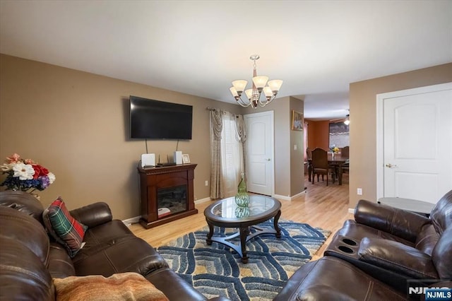 861 Birch St, Perth Amboy, NJ 08861 - living area with a chandelier, light wood-style floors, a glass covered fireplace, and baseboards