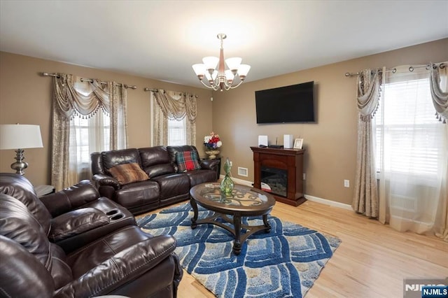 861 Birch St, Perth Amboy, NJ 08861 - living room with a chandelier, light wood-style flooring, a fireplace, and baseboards
