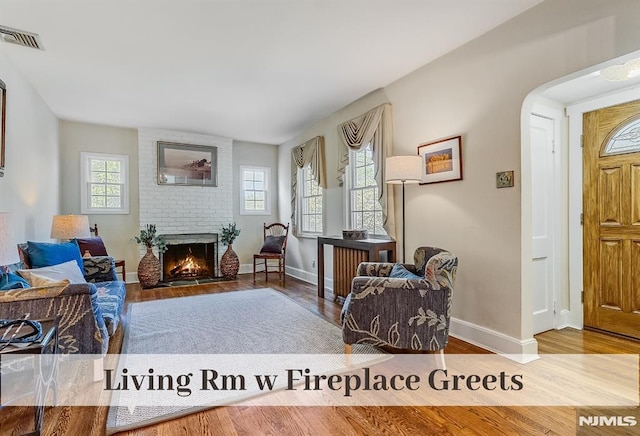 640 E Glen Ave, Ridgewood, NJ 07450 - living room featuring healthy amount of natural light, arched walkways, wood finished floors, and baseboards