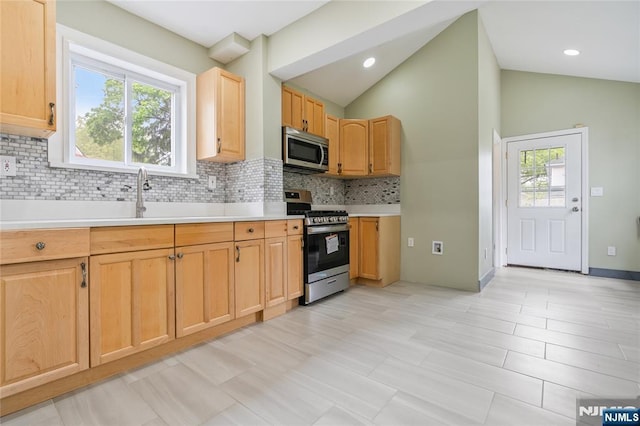 1153 Margaret St, Teaneck, NJ 07666 - kitchen with stainless steel appliances, vaulted ceiling, decorative backsplash, light countertops, and light brown cabinets
