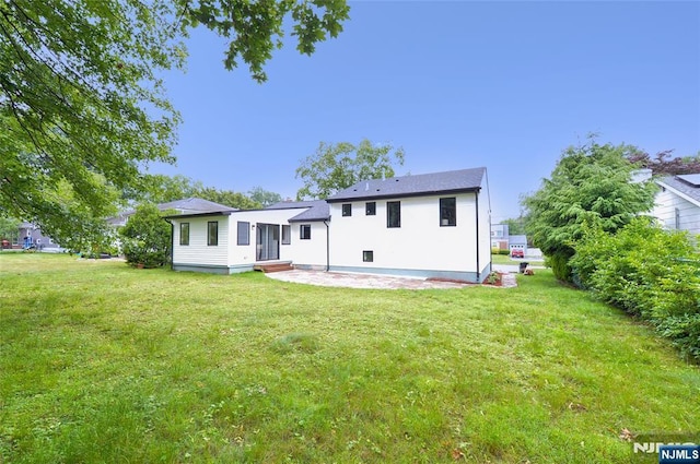 15-22 Radburn Rd, Fair Lawn, NJ 07410 - back of property featuring a lawn and a patio area