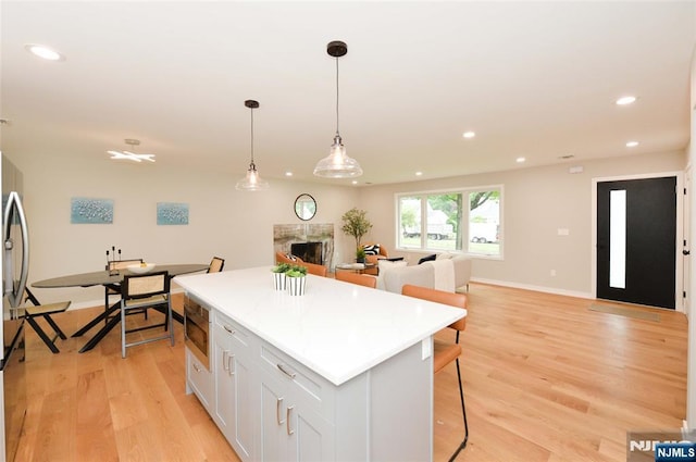 15-22 Radburn Rd, Fair Lawn, NJ 07410 - kitchen featuring a kitchen island, light wood-style flooring, open floor plan, recessed lighting, and a high end fireplace