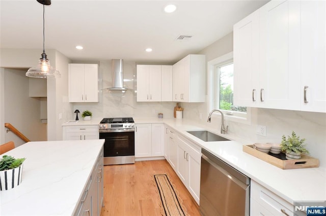 15-22 Radburn Rd, Fair Lawn, NJ 07410 - kitchen with stainless steel appliances, wall chimney range hood, decorative backsplash, light wood finished floors, and white cabinets