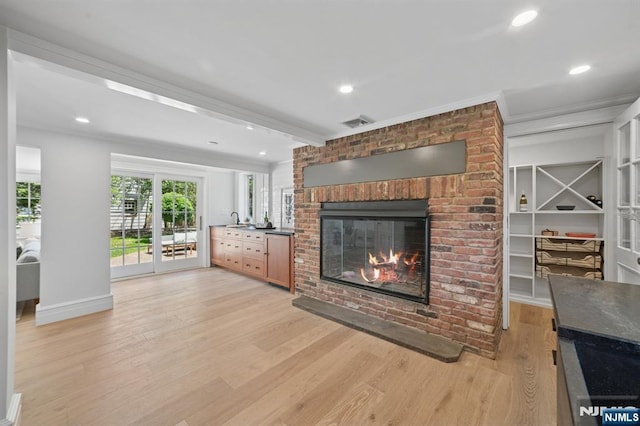 249 Valley Rd, Montclair, NJ 07042 - unfurnished living room with a brick fireplace, light wood-type flooring, baseboards, a sink, and recessed lighting