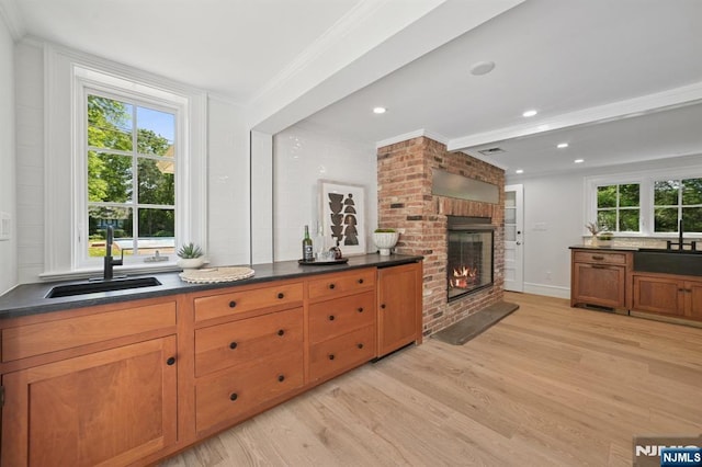 249 Valley Rd, Montclair, NJ 07042 - kitchen featuring a sink, light wood-type flooring, crown molding, dark countertops, and brown cabinets