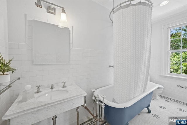 249 Valley Rd, Montclair, NJ 07042 - bathroom featuring tile walls, healthy amount of natural light, a sink, wainscoting, and toilet