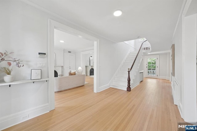 249 Valley Rd, Montclair, NJ 07042 - entrance foyer featuring crown molding, stairs, light wood-type flooring, a large fireplace, and baseboards