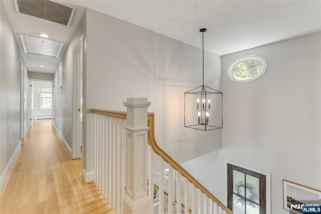61 Ferndale Rd, Paramus, NJ 07652 - corridor with an upstairs landing, attic access, light wood-type flooring, baseboard heating, and a chandelier