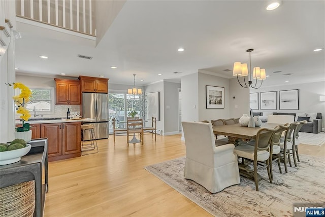 61 Ferndale Rd, Paramus, NJ 07652 - dining area with a chandelier, crown molding, light wood-style floors, recessed lighting, and baseboards