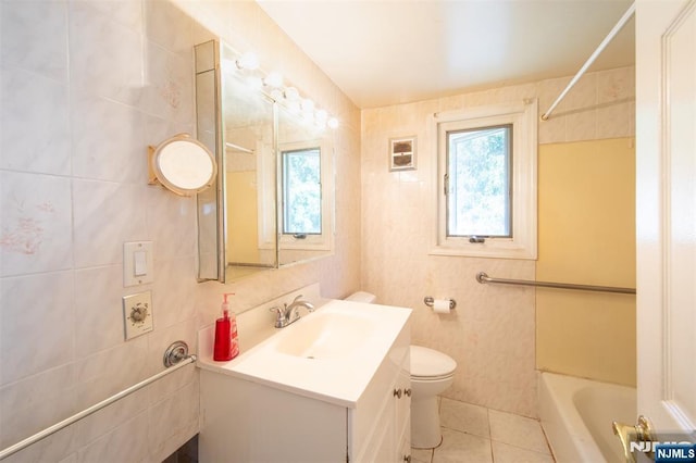 65 Byrne St, Hackensack, NJ 07601 - full bath with tile walls, a tub to relax in, vanity, toilet, and tile patterned floors
