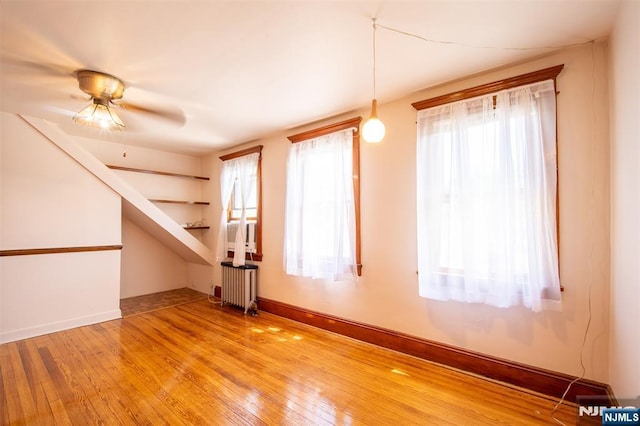 65 Byrne St, Hackensack, NJ 07601 - empty room featuring radiator heating unit, light wood-style floors, ceiling fan, and baseboards
