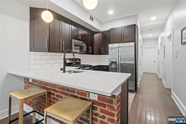 172 S St Unit 2A, Jersey City, NJ 07307 - kitchen with appliances with stainless steel finishes, tasteful backsplash, light countertops, wood-type flooring, and baseboards
