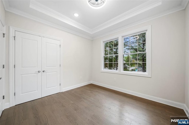 16 Coles Ct, River Edge, NJ 07661 - unfurnished bedroom featuring dark wood-style floors, ornamental molding, baseboards, a closet, and a raised ceiling