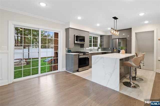 16 Coles Ct, River Edge, NJ 07661 - kitchen with stainless steel appliances, gray cabinetry, a sink, pendant lighting, and a center island