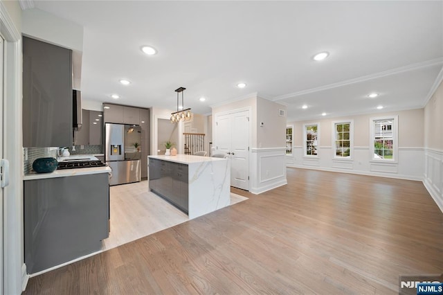 16 Coles Ct, River Edge, NJ 07661 - kitchen featuring stainless steel fridge, light countertops, a center island, light wood finished floors, and decorative light fixtures