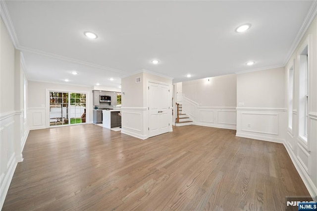 16 Coles Ct, River Edge, NJ 07661 - unfurnished living room featuring a decorative wall, ornamental molding, light wood-style floors, wainscoting, and stairway