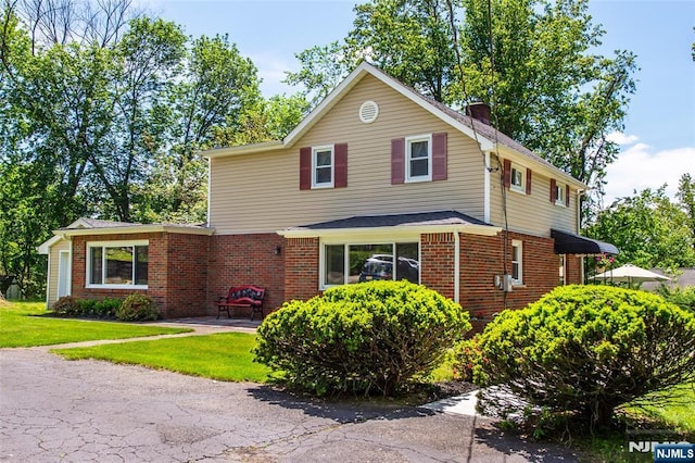 16 Dalewood Rd, Wayne, NJ 07470 - view of front of property featuring a front lawn, a chimney, and brick siding