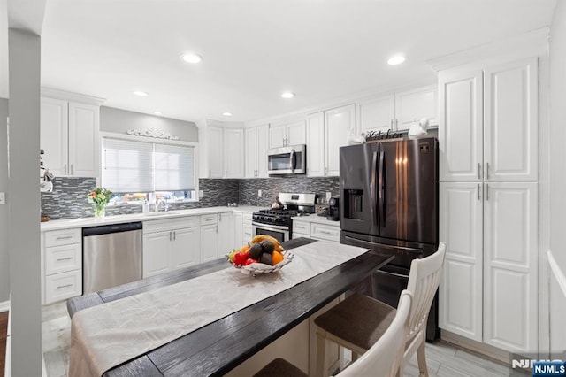 97 Avenue Ave, Lodi, NJ 07644 - kitchen with appliances with stainless steel finishes, decorative backsplash, white cabinets, a sink, and recessed lighting