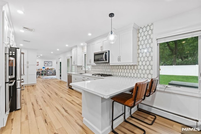 4 Kimberly Way, River Edge, NJ 07661 - kitchen featuring stainless steel appliances, a sink, white cabinetry, light countertops, and a kitchen breakfast bar