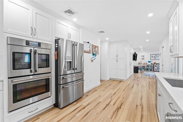 4 Kimberly Way, River Edge, NJ 07661 - kitchen featuring stainless steel appliances, white cabinets, recessed lighting, light countertops, and light wood-style flooring