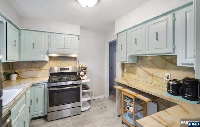 202 Linden Ave, Verona, NJ 07044 - kitchen featuring stainless steel range with gas stovetop, decorative backsplash, under cabinet range hood, and light tile patterned floors