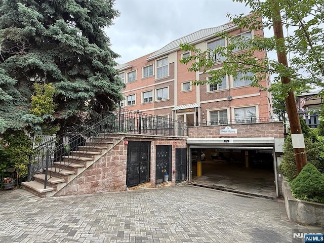 124 68th St Unit 204, Guttenberg, NJ 07093 - view of property featuring decorative driveway, a garage, and stairs