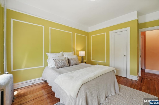 50 Reservoir Ave Unit 201, Jersey City, NJ 07307 - bedroom with wood finished floors, baseboards, and radiator