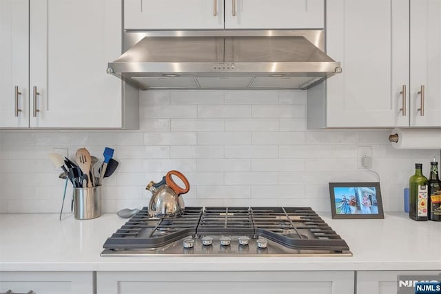 83 Landmark Ln, Fair Lawn, NJ 07410 - kitchen with wall chimney range hood, stainless steel gas cooktop, backsplash, and light countertops
