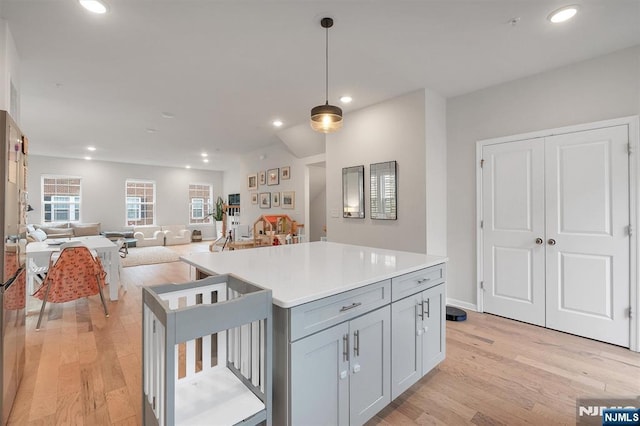 83 Landmark Ln, Fair Lawn, NJ 07410 - kitchen featuring light wood-style floors, a kitchen island, recessed lighting, hanging light fixtures, and open floor plan