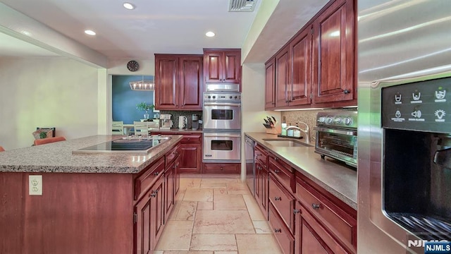 27 Bristol Pl, Wayne, NJ 07470 - kitchen featuring appliances with stainless steel finishes, stone tile flooring, recessed lighting, tasteful backsplash, and a sink