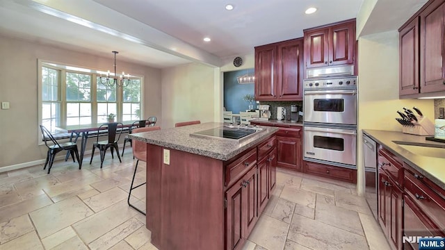 27 Bristol Pl, Wayne, NJ 07470 - kitchen featuring stainless steel appliances, a chandelier, recessed lighting, stone tile floors, and reddish brown cabinets