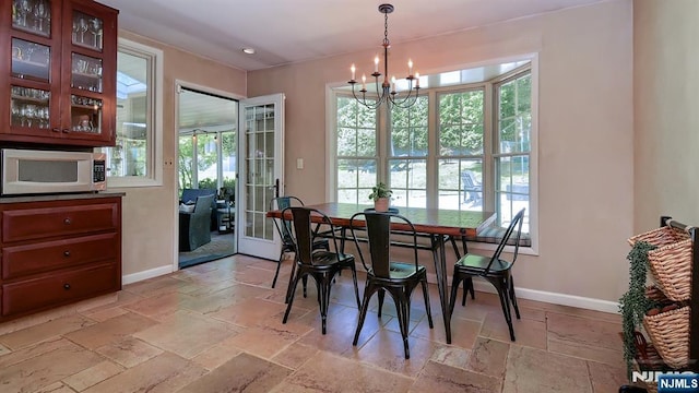27 Bristol Pl, Wayne, NJ 07470 - dining room featuring stone tile flooring, a chandelier, and baseboards