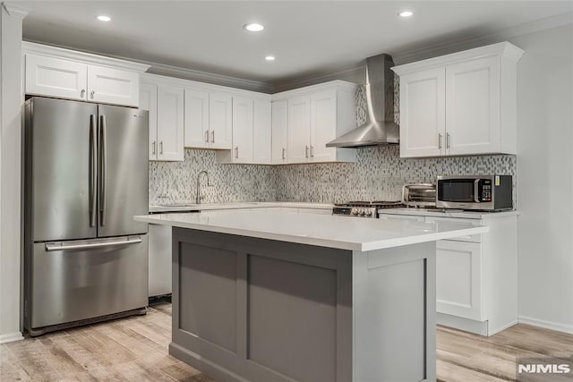 53 Princeton Pl, Wayne, NJ 07470 - kitchen with stainless steel appliances, wall chimney exhaust hood, white cabinetry, light wood-style floors, and recessed lighting