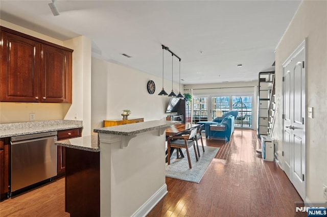 22 Ave At Port Imperial Unit 219, West New York, NJ 07093 - kitchen featuring dishwasher, open floor plan, hardwood / wood-style flooring, light stone counters, and decorative light fixtures