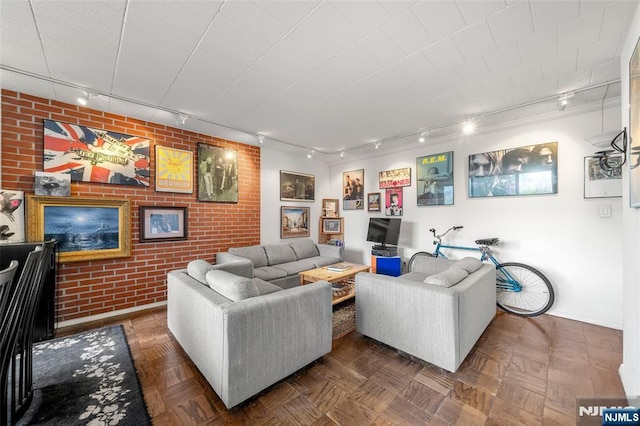 9060 Palisade Unit 612, North Bergen, NJ 07047 - living area with track lighting, brick wall, an accent wall, and baseboards