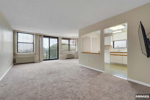 200 Division Unit 6H, Cliffside Park, NJ 07010 - unfurnished living room with light carpet, baseboards, a sink, and a textured ceiling