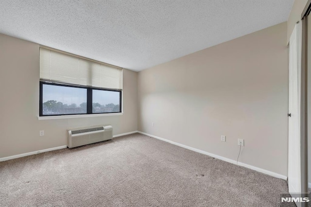200 Division Unit 6H, Cliffside Park, NJ 07010 - empty room featuring a wall unit AC, carpet flooring, a textured ceiling, and baseboards