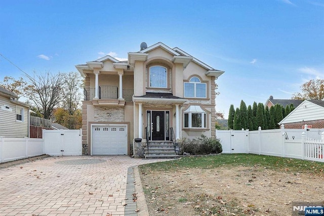 238 E Johnson Ave, Bergenfield, NJ 07621 - view of front of home featuring a gate, a balcony, stone siding, decorative driveway, and an attached garage