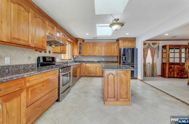 238 E Johnson Ave, Bergenfield, NJ 07621 - kitchen with appliances with stainless steel finishes, under cabinet range hood, a skylight, dark stone counters, and a sink