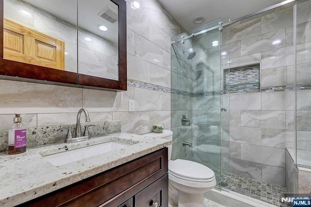 238 E Johnson Ave, Bergenfield, NJ 07621 - bathroom featuring a shower stall, vanity, toilet, and tile walls