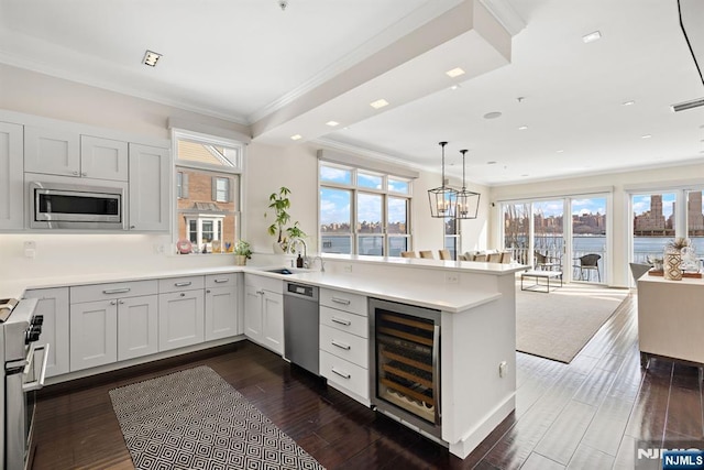 443 Albany Ct Unit 443, West New York, NJ 07093 - kitchen with beverage cooler, appliances with stainless steel finishes, a peninsula, a sink, and crown molding