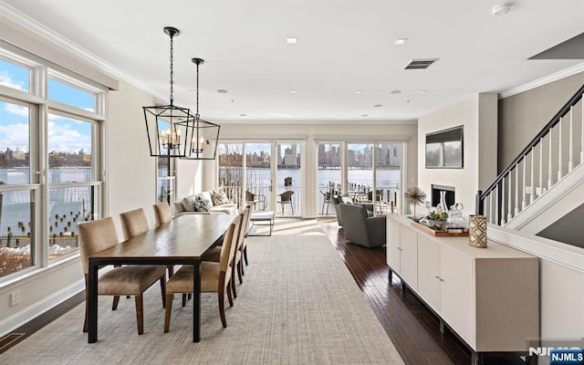 443 Albany Ct Unit 443, West New York, NJ 07093 - dining space featuring plenty of natural light, a chandelier, dark wood-style flooring, stairs, and ornamental molding