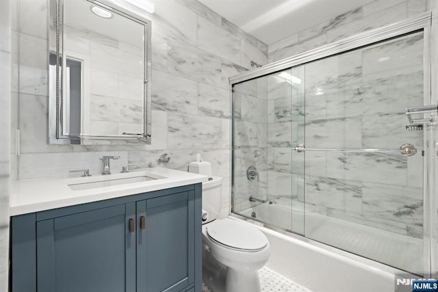 443 Albany Ct Unit 443, West New York, NJ 07093 - bathroom featuring toilet, vanity, combined bath / shower with glass door, and tile walls