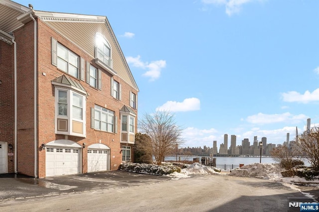 443 Albany Ct Unit 443, West New York, NJ 07093 - view of building exterior with a garage, driveway, and a water view