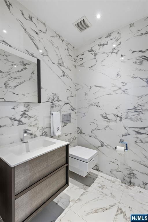 443 Albany Ct Unit 443, West New York, NJ 07093 - bathroom featuring vanity, stone wall, marble tiled flooring, and recessed lighting